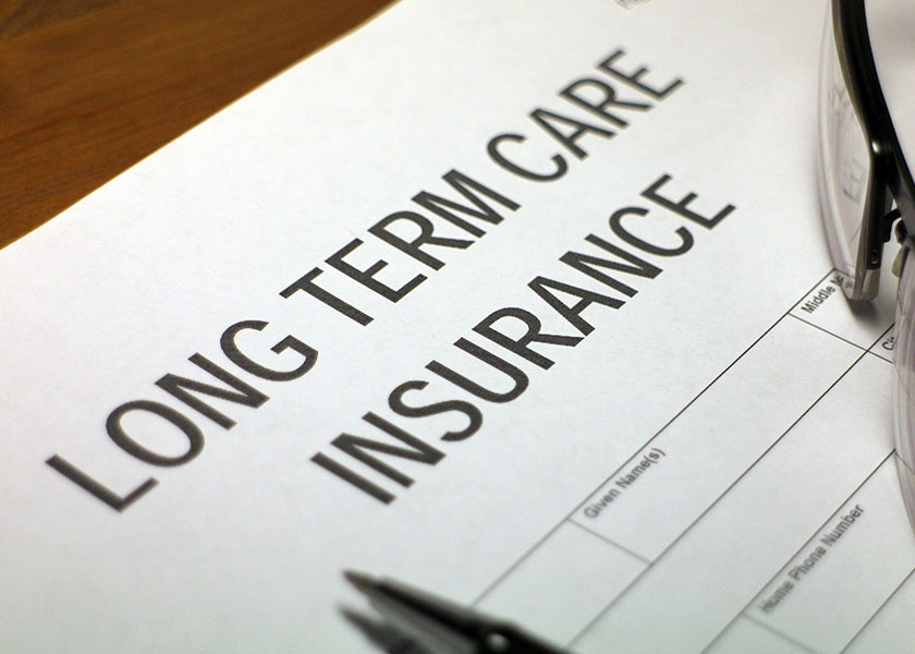 Long-term care insurance form with pencil and glasses.